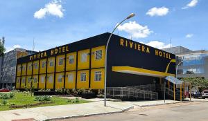 a yellow and black building in a parking lot at Riviera Hotel by Bsb Inn in Brasília +38 photos