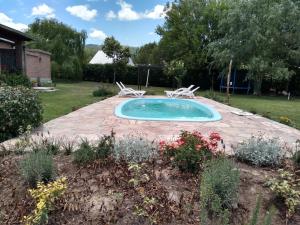 a swimming pool in a yard with two chairs at El Indalo La Calderilla in La Caldera