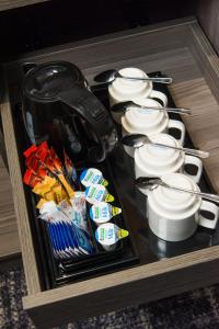 a drawer with cups and utensils in a room at Eden Plaza Kensington in London