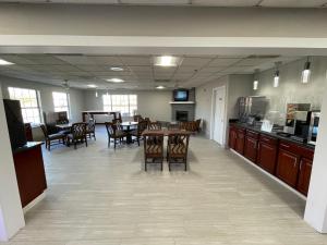 a large room with a table and chairs and a kitchen at Baymont by Wyndham Adairsville in Adairsville