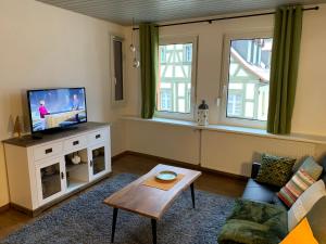 a living room with a tv and a couch and a table at Villa Ammonit in Pottenstein