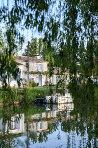 ein Haus im Wasser eines Sees reflektiert in der Unterkunft L'instant bleu in Marans