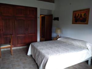 1 dormitorio con 1 cama, 1 silla y 1 puerta en El Indalo La Calderilla en Salta