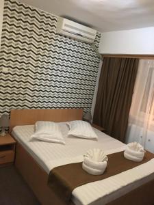 a bedroom with a bed with two towels on it at Karla Residence / Greta Residence in Reşiţa