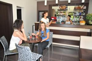 a group of people sitting at a table in a bar at Hotel Burgas Free University in Burgas