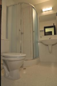 
a white toilet sitting in a bathroom next to a shower at Hotel Burgas Free University in Burgas
