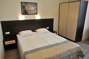 a bedroom with a large bed with two pillows at Hotel Burgas Free University in Burgas