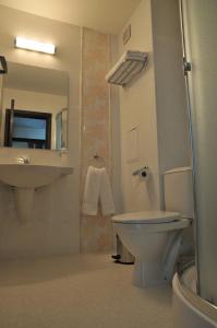 a bathroom with a white toilet and a sink at Hotel Burgas Free University in Burgas