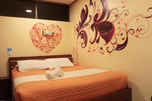 Hostal Dulce Amanecer في بانوس: غرفة نوم مع سرير وبقلب على الحائط
