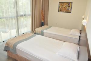 two beds in a room with a window at Hotel Burgas Free University in Burgas
