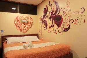 a bedroom with a bed with a heart on the wall at Hostal Dulce Amanecer in Baños