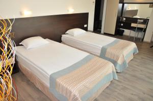 two twin beds in a room with at Hotel Burgas Free University in Burgas