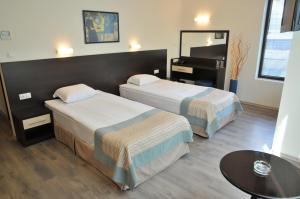 a hotel room with two beds and a piano at Hotel Burgas Free University in Burgas