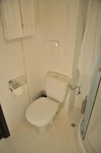 a white bathroom with a toilet and a shower at Hotel Burgas Free University in Burgas