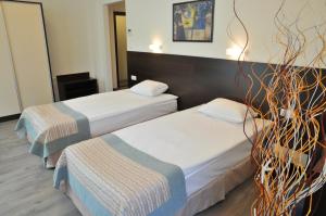 a hotel room with two beds and a mirror at Hotel Burgas Free University in Burgas