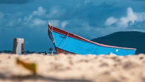 a boat sitting on top of a sandy beach at ApartPousada Residencial dos Reis in São Francisco do Sul