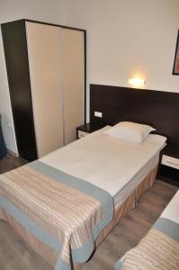 a bedroom with a large bed and a closet at Hotel Burgas Free University in Burgas