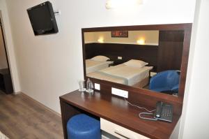 a hotel room with a desk and a mirror at Hotel Burgas Free University in Burgas