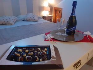 a table with a bottle of wine and a box of chocolates at B&B BABY D in Montalto Uffugo