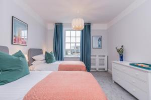 a bedroom with two beds and a window at Oxfordshire Living - The Spencer Apartment - Woodstock in Woodstock