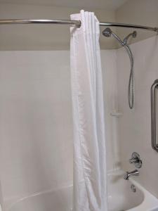 einen weißen Duschvorhang in einem weißen Badezimmer in der Unterkunft MainStay Suites Cartersville in Cartersville