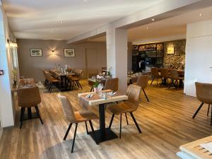 a restaurant with tables and chairs in a room at Logis du Champ De Mars in Puy-Saint-Martin