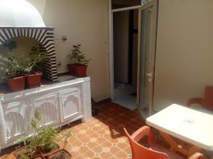 a room with a table and potted plants on a cabinet at Flashback House in Marrakesh