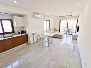 a kitchen and living room with a table and chairs at Vasilo Court Seaview City Apartment in Larnaca