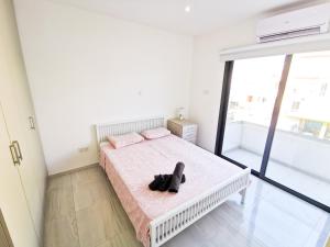 a bedroom with a bed with a black shoe on it at Vasilo Court Seaview City Apartment in Larnaca