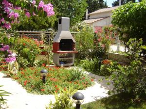 un jardín con barbacoa en medio de flores en Apartments Biskup, en Privlaka