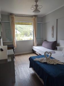 a hotel room with two beds and a window at Flat Cavalinho Branco - Apto 509 in Águas de Lindoia