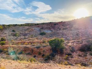 a view of the desert with the sun setting on a hill at Die Kliphuisie in Hoopvol +6 photos