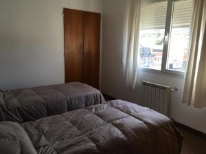 コモドーロ・リバダビアにあるCactuSのベッド2台と窓のある寝室