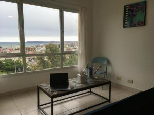 コモドーロ・リバダビアにあるCactuSの窓付きの部屋で、ノートパソコン付きのテーブルが備わります。
