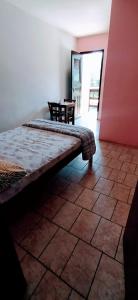 a room with a bench in a room with a table at Pousada Minas Gerais in Tramandaí