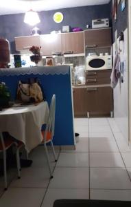 a kitchen with a table and a blue wall at Residencial savassi in Betim +16 photos