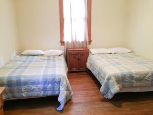 2 Betten in einem Zimmer mit Fenster in der Unterkunft Aunt Jane's Two in Put-in-Bay