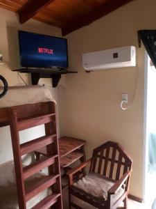 Habitación con TV, silla y escritorio. en Hospedar en Puerto Rico
