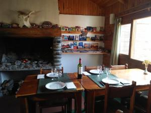 a dining room with a table with a bottle of wine at ESTANCIA LA SERENA in Perito Moreno