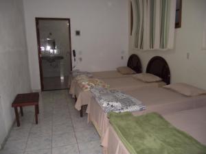 eine Gruppe von 4 Betten in einem Zimmer in der Unterkunft Hotel Miguel Pereira in Miguel Pereira