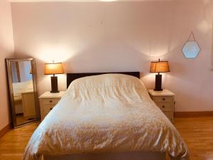 a bedroom with a bed and two lamps on dressers at 4 Bedrooms with stunning Lake View Drumcoura Lake Resort beside Saloon & equestrian Centre, Lakes & Forest in Ballinamore
