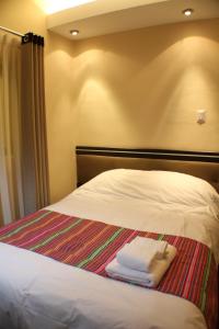 una cama con tres toallas plegadas sentadas en ella en Tampu Hotel, en Cusco