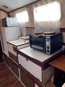 a small kitchen with a microwave and refrigerator in an rv at Séjour à bord d'un voilier type studio in Pointe-à-Pitre