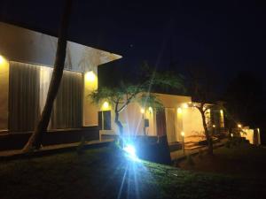 a person standing in front of a house at night at Peakaavu Cottages in Idukki