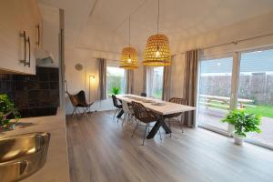 a kitchen and dining room with a table and chairs at Jacuzzi & Sauna Villa 2 in Tzummarum