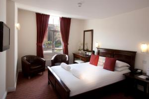 a hotel room with a bed and a chair at Park Central Hotel in Bournemouth