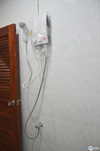 un teléfono colgando en una pared en un baño en C9 Hotel - โรงแรมซีไนน์ en Trang