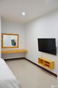 um quarto com uma televisão de ecrã plano na parede em C9 Hotel - โรงแรมซีไนน์ em Trang