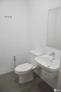 Baño blanco con aseo y lavamanos en C9 Hotel - โรงแรมซีไนน์ en Trang