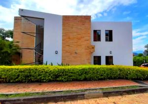 a house with a bush in front of it at Casa Campestre con Piscina Privada Anapoima in Girardot
